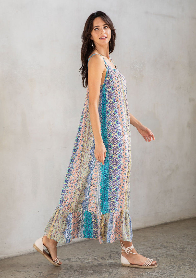 [Color: Turquoise Multi] A model wearing a vacation ready sleeveless maxi dress in a multicolor mixed print. With a ruffled round neckline, a relaxed flowy fit, and metallic thread details.