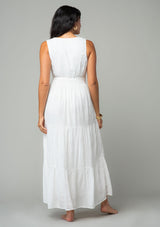 [Color: Off White] A back facing image of a brunette model wearing a sleeveless white bohemian eyelet maxi dress. With a v neckline, a long tiered skirt, and a smocked elastic waist. A classic bohemian white maxi dress for Summer. 