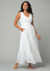 [Color: Off White] A full body front facing image of a brunette model wearing a sleeveless white bohemian eyelet maxi dress. With a v neckline, a long tiered skirt, and a smocked elastic waist. A classic bohemian white maxi dress for Summer. 