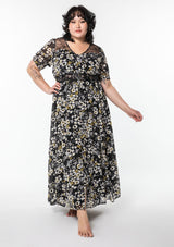 [Color: Black/Lemon] A model wearing a dreamy flowy bohemian maxi dress in a black and yellow floral print. With short puff sleeves, sheer lace accents, and a button front.