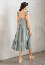 [Color: Silver Sage] A model wearing a classic sage green maxi dress designed in soft cotton gauze. With a scooped neckline, adjustable ruffled straps, and side pockets.