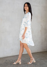 [Color: Ivory/Slate] A model wearing a flowy white bohemian mini dress with floral embroidery. 