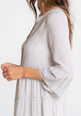 [Color: Grey/Ivory] A model wearing a classic relaxed yarn dye mini shirt dress in a grey and ivory stripe. With three quarter length bell sleeves, a tiered skirt, and a loose, relaxed silhouette.