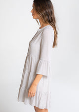[Color: Grey/Ivory] A model wearing a classic relaxed yarn dye mini shirt dress in a grey and ivory stripe. With three quarter length bell sleeves, a tiered skirt, and a loose, relaxed silhouette.