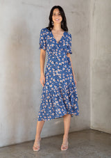 [Color: Navy/Cream] A sweet take on spring dressing, this pretty red midi wrap dress is designed in a vintage inspired floral print and classic wrap silhouette. Featuring short puff sleeves with a bow accent, a ruffled asymmetric hemline, and a side tie waist closure that can be adjusted to fit your curves. This beautiful dress comes in a vibrant blue or classic red, and is available in XS - XL.