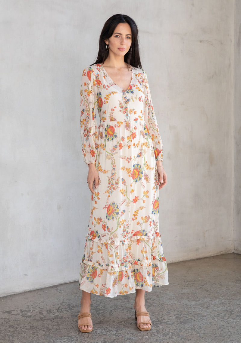[Color: Ivory/Coral] A model wearing a bohemian sheer chiffon maxi dress in a coral floral print. 