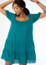 [Color: Teal] A model wearing a bohemian white cotton mini dress with short puff sleeves and a relaxed flowy fit.