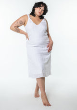 [Color: White] A model wearing a bohemian cotton white mid length dress with tank top straps and a v neckline in front and back.