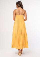 [Color: Sherbert] A woman wearing a yellow flowy bohemian maxi dress with crochet trim, gold toned hardware, and adjustable spaghetti straps.