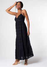 [Color: Black] A model wearing a bohemian black lace maxi dress with spaghetti straps, a flowy skirt, and a v neckline.