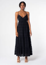 [Color: Black] A model wearing a bohemian black lace maxi dress with spaghetti straps, a flowy skirt, and a v neckline.
