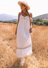 [Color: Off White/Natural] A full body front facing image of a red headed model wearing an off white cotton gauze sleeveless maxi dress with a natural crochet trim top and hemline. With adjustable spaghetti straps and a flowy fit.
