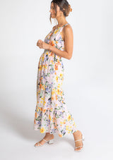 [Color: Blush/Orange] A model wearing a romantic bohemian halter maxi dress in a pink and orange large floral print. 