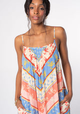 [Color: Indigo/Red] A model wearing a flowy relaxed bohemian beach maxi dress in a blue and red floral chevron stripe print. With adjustable spaghetti straps and a scooped neckline. 