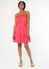 [Color: Watermelon] A front facing, full body image of a black model wearing a bright pink bohemian sleeveless mini tank dress with spaghetti straps, a crochet knit trim, and a tassel tie waist belt. 