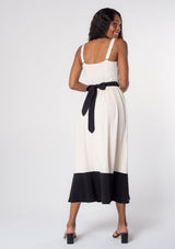 [Color: Vanilla/Black] A model wearing an elegant, timeless white and black maxi dress in a linen blend, with tank top straps, a v neckline, and a contrast waist belt that ties in the back. 