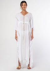 [Color: White] A woman wearing a sheer white bohemian beach cover up maxi dress with lace and tassel trim and side slits. A kimono kaftan maxi dress perfect for vacations! 