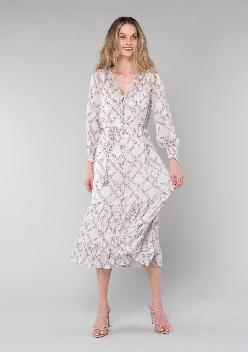 [Color: Ivory/Plum] A front facing image of a blonde model wearing a romantic bohemian mid length chiffon dress in an ivory and plum purple floral print. A spring dress with long sleeves, a self covered button front, a v neckline, a flowy tiered skirt, and a self tie waist belt. 