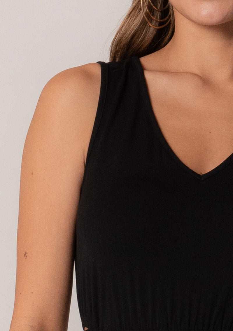 [Color: Black] A close up front facing image of a brunette model wearing a soft and stretchy knit sleeveless maxi dress in black. With a v neckline, sexy side waist cutouts, and a self tie belt. 