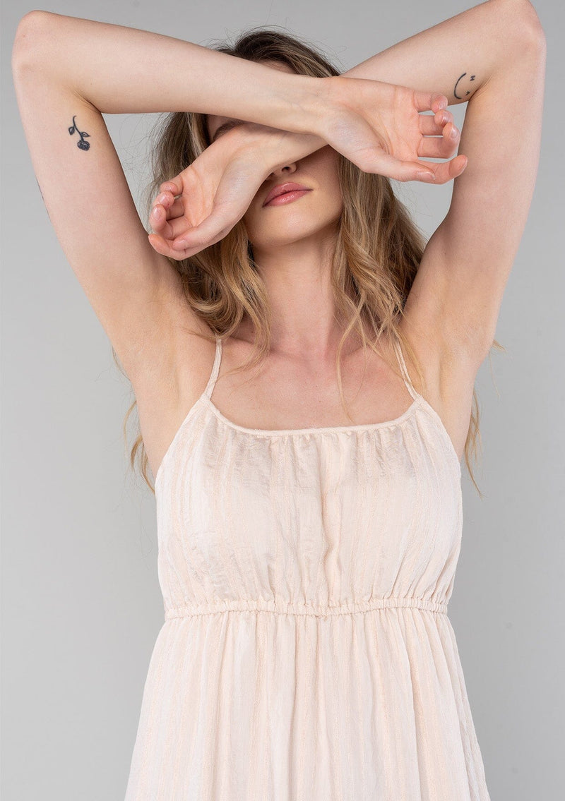 [Color: Natural] A close up front facing image of a blonde model wearing a bohemian spring maxi tank dress in a natural shadow stripe. With adjustable spaghetti straps, a round neckline, a tiered flowy skirt, a back cutout detail, and a back tie waist detail. 