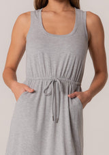 [Color: Heather Grey] A close up front facing image of a brunette model wearing a sporty sleeveless lounge mini dress in heather grey. Designed in a soft bamboo knit with a scoop neckline, side pockets, and an adjustable drawstring waist. 