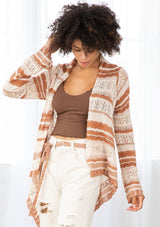 [Color: Cream/Rust] A model wearing a cream and rust striped rochet cardigan. A vintage inspired style with a waterfall hemline and a removable waist tie. 