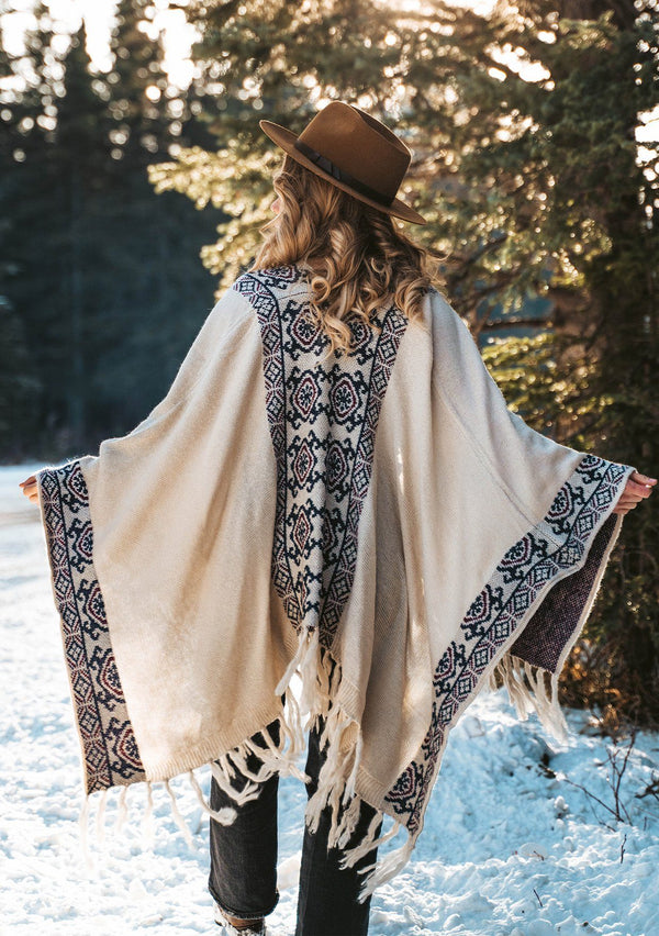 [Color: Natural/Midnight] The ultimate bohemian poncho sweater, in an eye catching Southwestern style pattern. Featuring a fringed handkerchief hemline, contrast ribbed details, and an easy open front. 