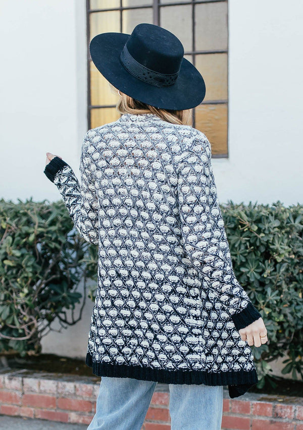 [Color: Black/OffWhite] A blond woman outside wearing an ultra soft chunky marled knit cardigan. Featuring a shawl collar and a contrast trim.