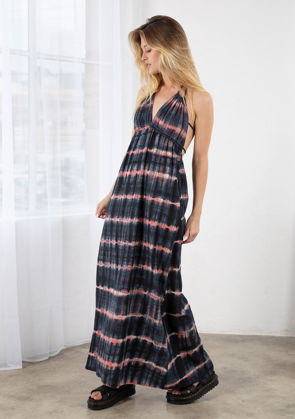 [Color: Navy/Rose] A blond model wearing a tie dye plaid maxi dress. Featuring a double strap tie back, a halter tie neckline, an empire waist, and side pockets. 