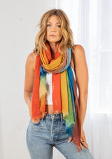 [Color: Rainbow] A model wearing a rainbow printed mesh scarf with a raw edge hem. 