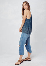 [Color: Dusty Navy] An image of a blonde model wearing a navy boho embroidered tank top with tassel ties. 