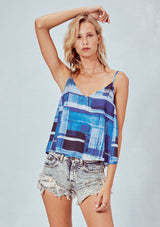 [Color: Blue] A blonde model wearing an abstract blue tank top with a flowy fit, v-neckline, and adjustable spaghetti straps. 