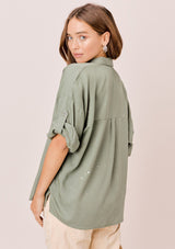 [Color: Olive] Lovestitch olive short sleeve, tencel, buttondown shirt with roll tab sleeves and paint splatter detail. 