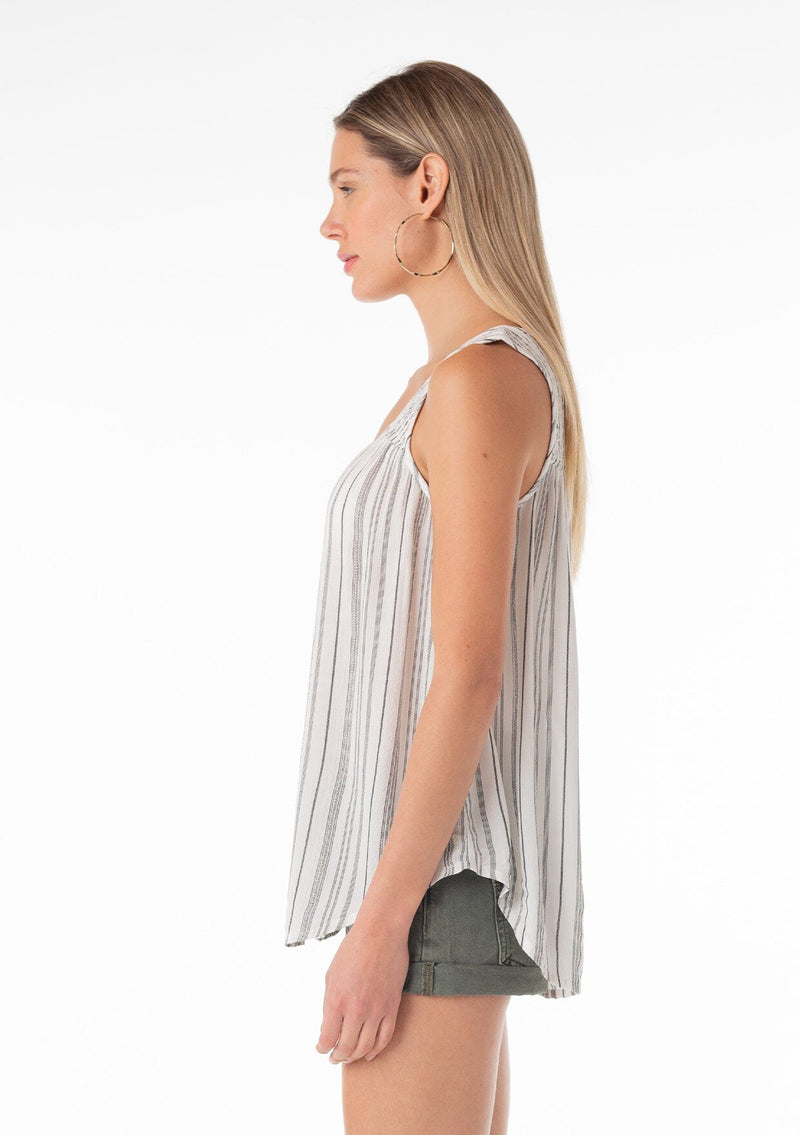 [Color: Off White/Black] A side facing image of a blonde model wearing a casual bohemian spring tank top in an off white and black stripe. With a v neckline, a smocked yoke detail, and a relaxed fit. 