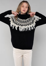 [Color: Black/Ivory] A cozy ski sweater with a bohemian twist. Featuring a warm turtleneck and a contrast knit yoke design and a fringed detail in front and back.