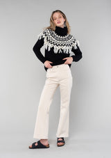 [Color: Black/Ivory] A cozy ski sweater with a bohemian twist. Featuring a warm turtleneck and a contrast knit yoke design and a fringed detail in front and back.