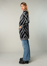 [Color: Charcoal/Black] A model wearing a charcoal and black tiger print cardigan. Featuring a mid length, long sleeves, side pockets, and an open front.