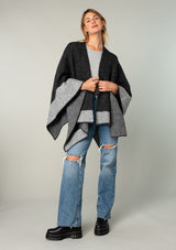 [Color: Heather Charcoal/Heather Cement] A full body front facing image of a blonde model wearing a soft and warm mid length sweater cape. An open front cape cardigan with a contrast border design. Perfect fall sweater, great for layering. 