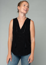 [Color: Black] A half body front facing image of a red headed model wearing a black eyelet bohemian tank top. With a split v neckline and tassel ties.