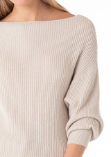 [Color: Heather Stone] A close up front facing image of a blonde model wearing an off white, stone grey waffle knit pullover sweater. With long sleeves, a relaxed fit, and a wide neckline that can be worn off the shoulder. 