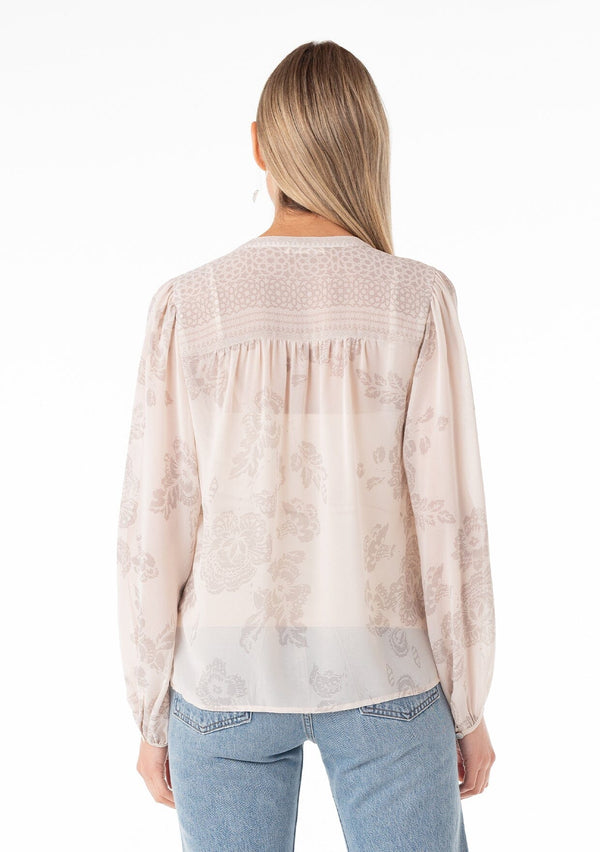 [Color: Natural/Taupe] A back facing image of a blonde model wearing a sheer chiffon bohemian spring blouse in a natural and taupe mixed floral print. With a button front, a v neckline, long sleeves, and a relaxed fit. 