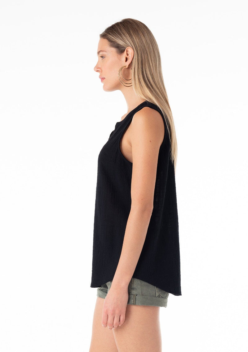 [Color: Black] A side facing image of a blonde model wearing a bohemian black cotton tank top with a split v neckline, embroidered trim, and a relaxed fit. 