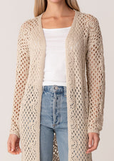 [Color: Natural] A close up front facing image of a blonde model wearing a classic bohemian cream colored mid length crochet cardigan.