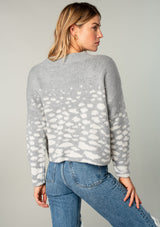 [Color: Heather Grey/Cream] A model wearing a fuzzy grey sweater in an abstract animal print. With a slightly cropped length, long sleeves, and a round neckline.