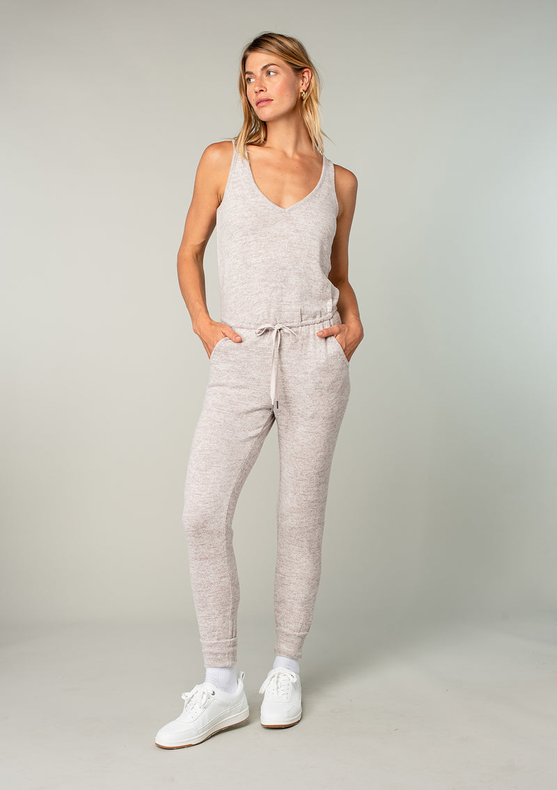 [Color: Heather Oatmeal] Girl wearing a cozy knit sleeveless lounge jumpsuit.