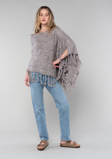 [Color: Grey/Rust] A vintage inspired sweater poncho knit from a grey speckled yarn. With a fringed hemline. 
