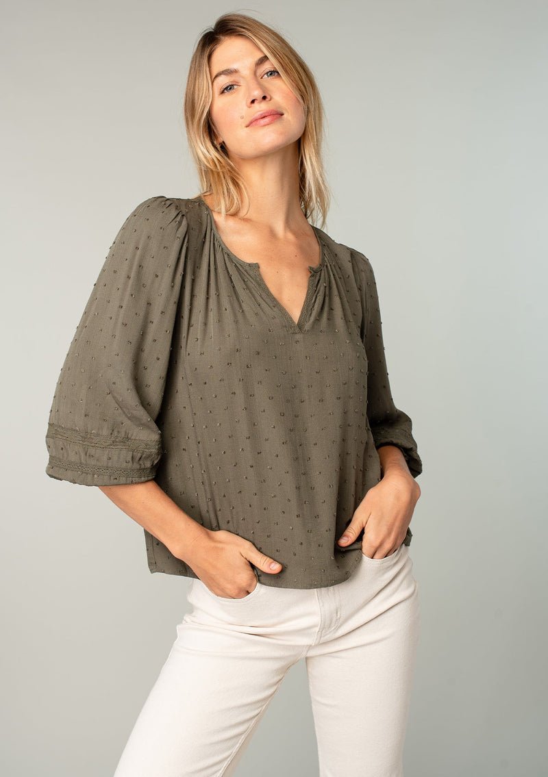 [Color: Olive] A front facing image of a blonde model wearing an olive green classic bohemian peasant top with voluminous lace trimmed long sleeves.