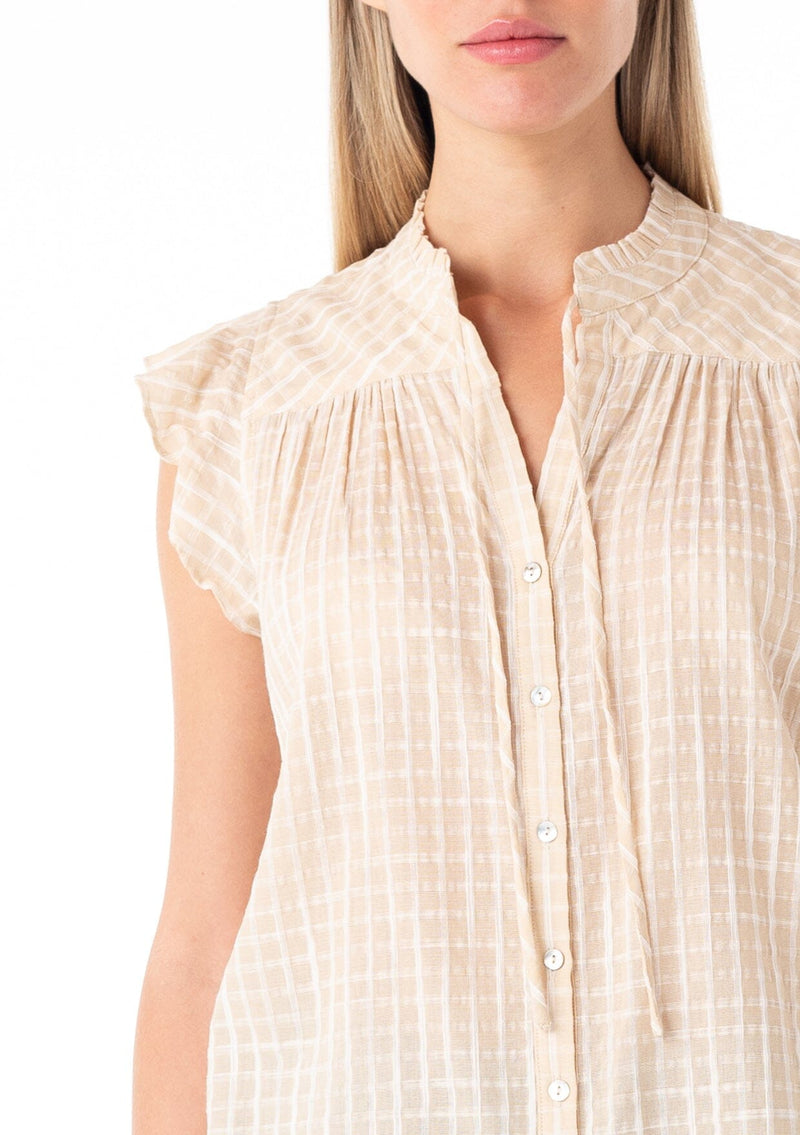 [Color: Natural] A close up front facing image of a blonde model wearing a best selling button front blouse in a natural cotton seersucker check print. With short flutter sleeves, a ruffled neckline, and neck ties.