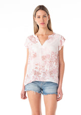 [Color: Ivory/Light Rust] A half body front facing image of a blonde model wearing a light spring top in a white and pink floral print. With short ruffled sleeves, a split v neckline, and a relaxed fit. 
