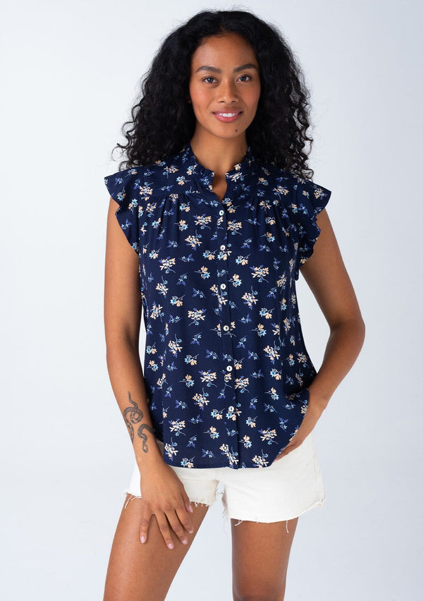 [Color: Navy/Coral] A front facing image of a brunette model wearing a classic bohemian button front top in a navy blue and coral floral print. With short flutter cap sleeves and a ruffled neckline. 